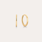 The 14K Recycled Solid Gold Plain Huggie Earring is shown on a light background, with one earring displayed from the side and the other highlighting its classic circular shape.