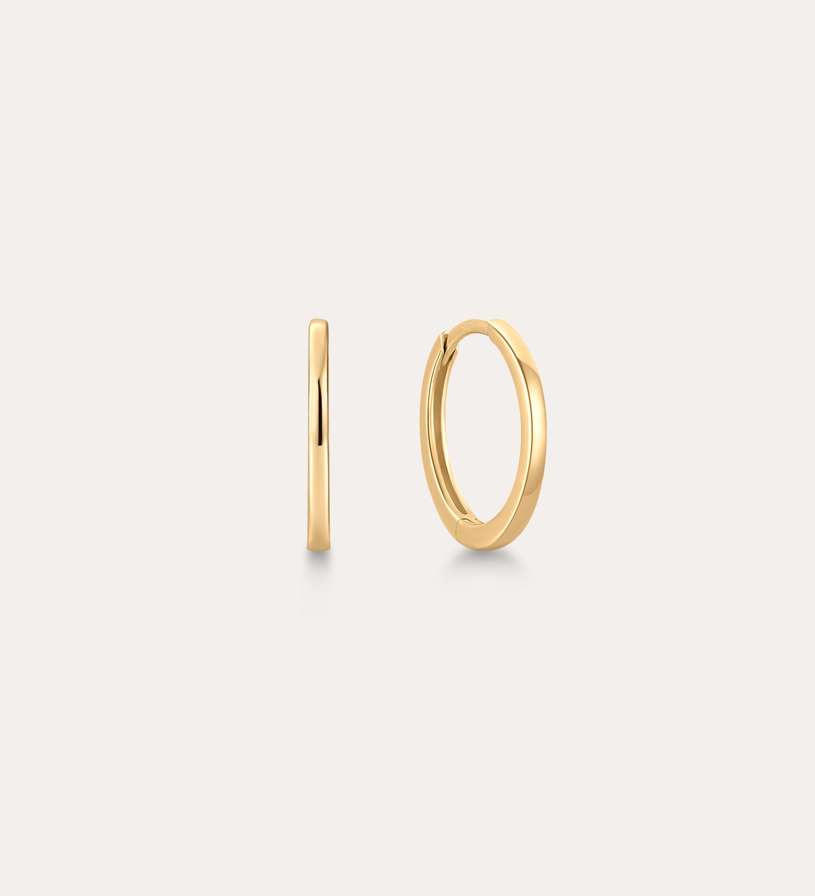 The 14K Recycled Solid Gold Plain Huggie Earring is shown on a light background, with one earring displayed from the side and the other highlighting its classic circular shape.