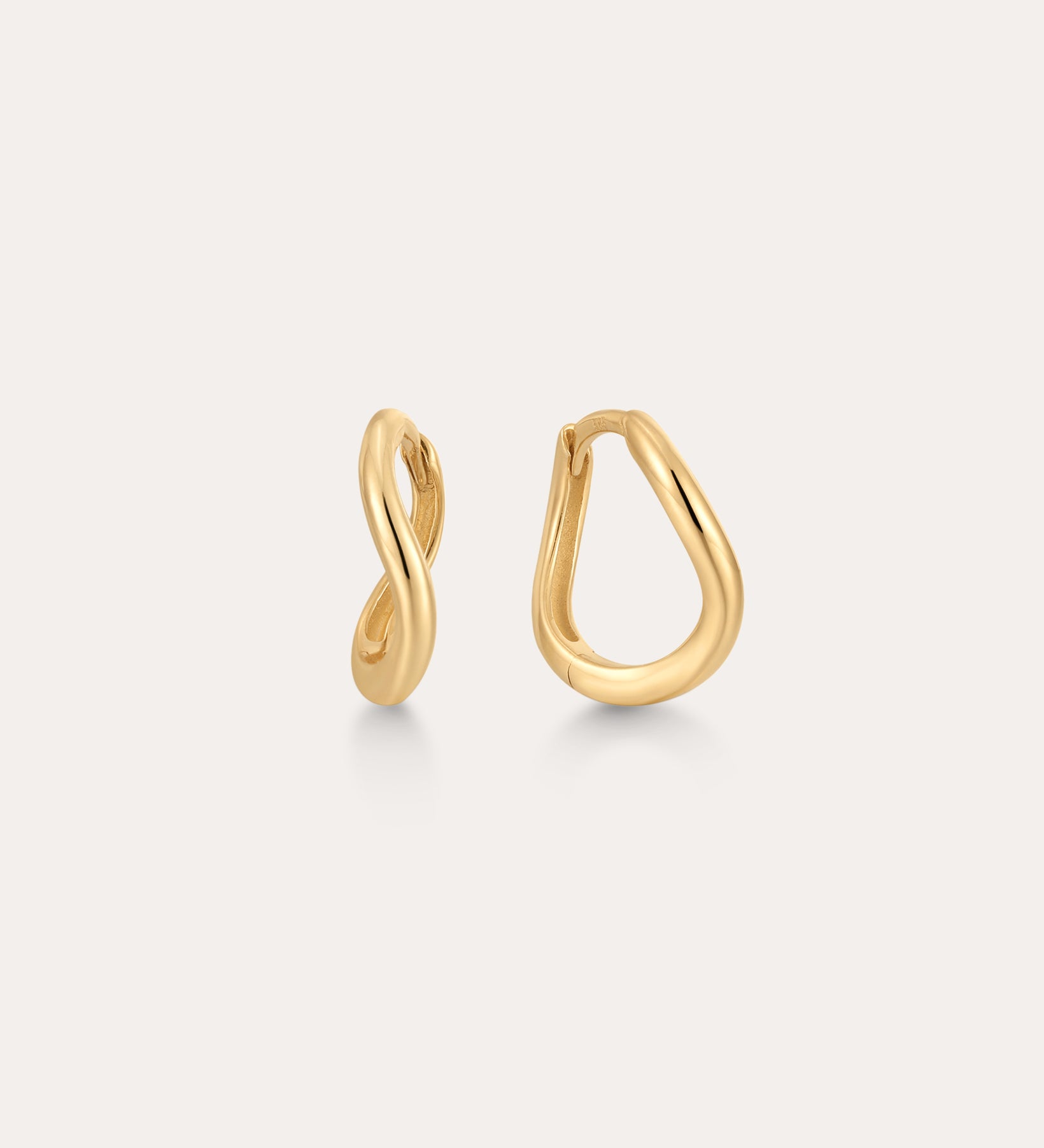 The 14K Recycled Solid Gold Twisted Huggie Earrings feature smooth, wavy, organic shapes and an asymmetrical design. These mini hoops are crafted from recycled gold and displayed on a plain light background.