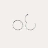 Two 14K Solid White Gold 20G Mini Clicker hoops are displayed on a plain white background—one closed, one slightly open—highlighting their simple, elegant circular design suitable for use as a nose ring or subtle ear accessory.