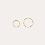 The 14K Solid Yellow Gold 20G Mini Clicker hoops, shown in two sizes on a plain white background, are perfect for classic cartilage wear or as minimalist hoop earrings.