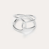 The Ayla Link Ring in Silver showcases a minimalist, modern design with two smooth, interlocking loops, set against a plain light background.