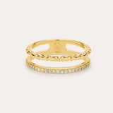The Molten Crystal Double Band Ring in Gold features 18k gold plating, two connected bands—one with a twisted rope design and the other adorned with cubic zirconia—shown against a light background.