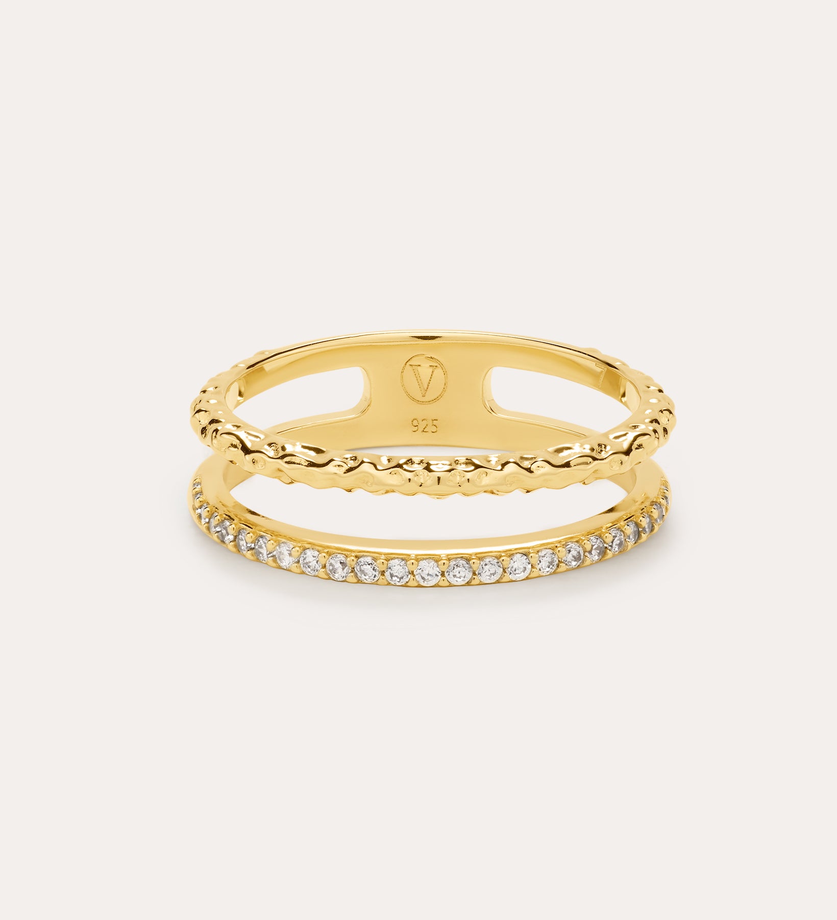 The Molten Crystal Double Band Ring in Gold features 18k gold plating, two connected bands—one with a twisted rope design and the other adorned with cubic zirconia—shown against a light background.