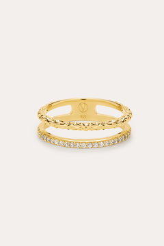 The Molten Crystal Double Band Ring in Gold features 18k gold plating, two connected bands—one with a twisted rope design and the other adorned with cubic zirconia—shown against a light background.