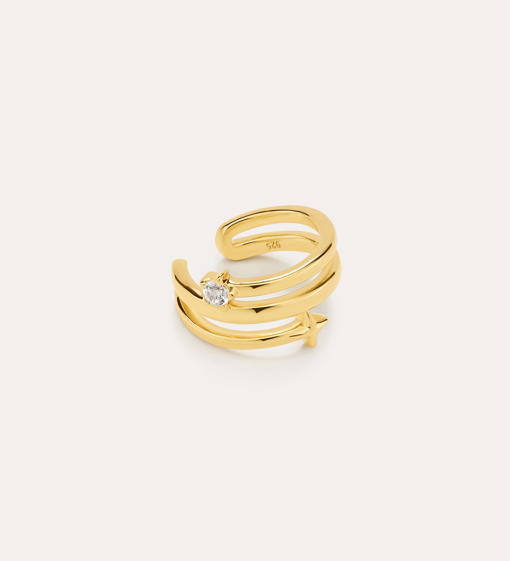 The Star Crystal Ear Cuff in Gold features a wrap-around design in 18k gold plating, adorned with a small crystal star and a clear round gemstone. This celestial accessory is displayed on a plain light beige background.