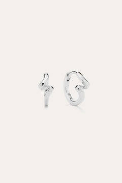 A pair of Ribbon Twist Huggies in sterling silver—one shaped like a lightning bolt, the other with a smooth, twisted ribbon design—are displayed against a plain white background.