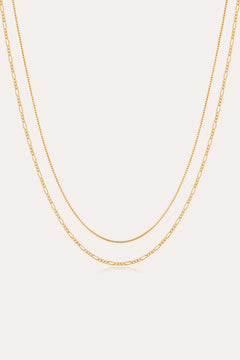 The Figaro And Box Chain Layered Necklace in 18k Gold Plated features a dual design: a sleek box chain above and elongated Figaro links below, beautifully displayed against a white background for an elegant layered look.