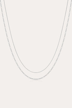 The Figaro And Box Chain Layered Necklace in Sterling Silver features a fine box chain and a longer Figaro link, both displayed against a plain white background for an elegant layered look.