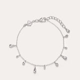 The Rhea Molten Cascade Bracelet in Silver features delicate rhodium-plated teardrop charms evenly spaced along a slender chain, complete with an adjustable clasp and extra extension links—ideal as a dainty stand-alone piece or layered for a chic, stacked style.