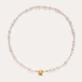 The Flora Multi Pearl Toggle Choker in Gold features irregularly shaped white freshwater pearls and a small 14K gold plated butterfly charm at the center, finished with a floral toggle clasp and displayed on a plain white background.