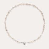The Flora Multi Pearl Toggle Choker in Sterling Silver is a delicate piece featuring irregularly shaped freshwater pearls and a small sterling silver bow charm at the center, elegantly displayed on a plain light background.
