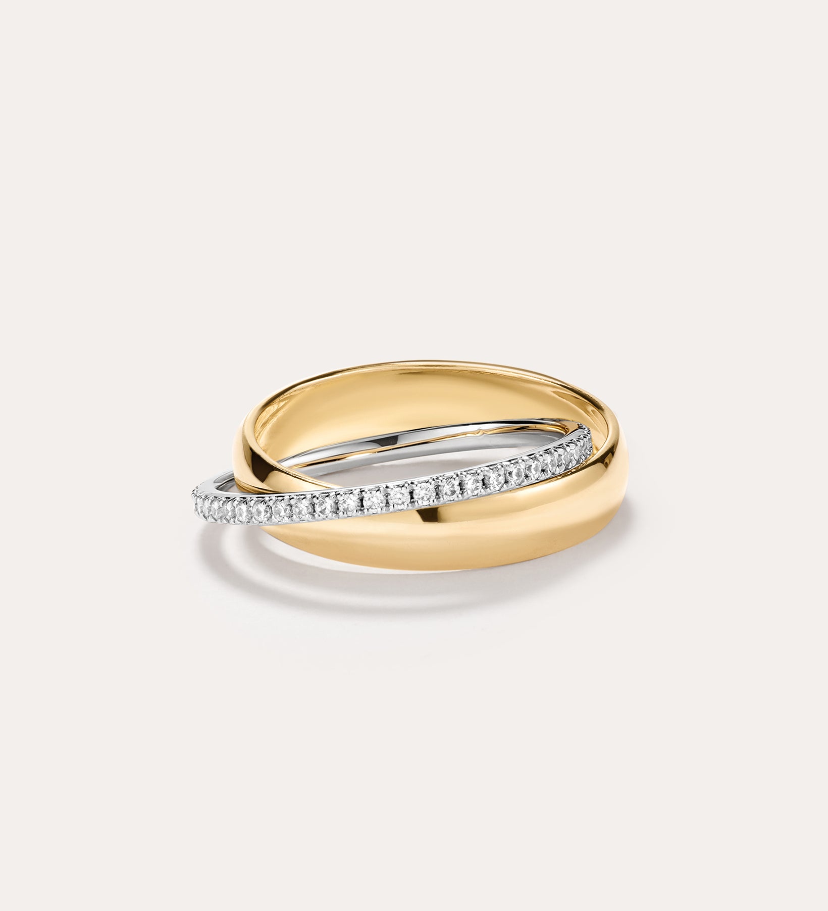 The Mixed Metal Interlocking Ring, featuring a 14K gold plated band intertwined with a slender silver band adorned with small diamonds and sparkling cubic zirconia, creates a modern, stylish statement against a plain light background.