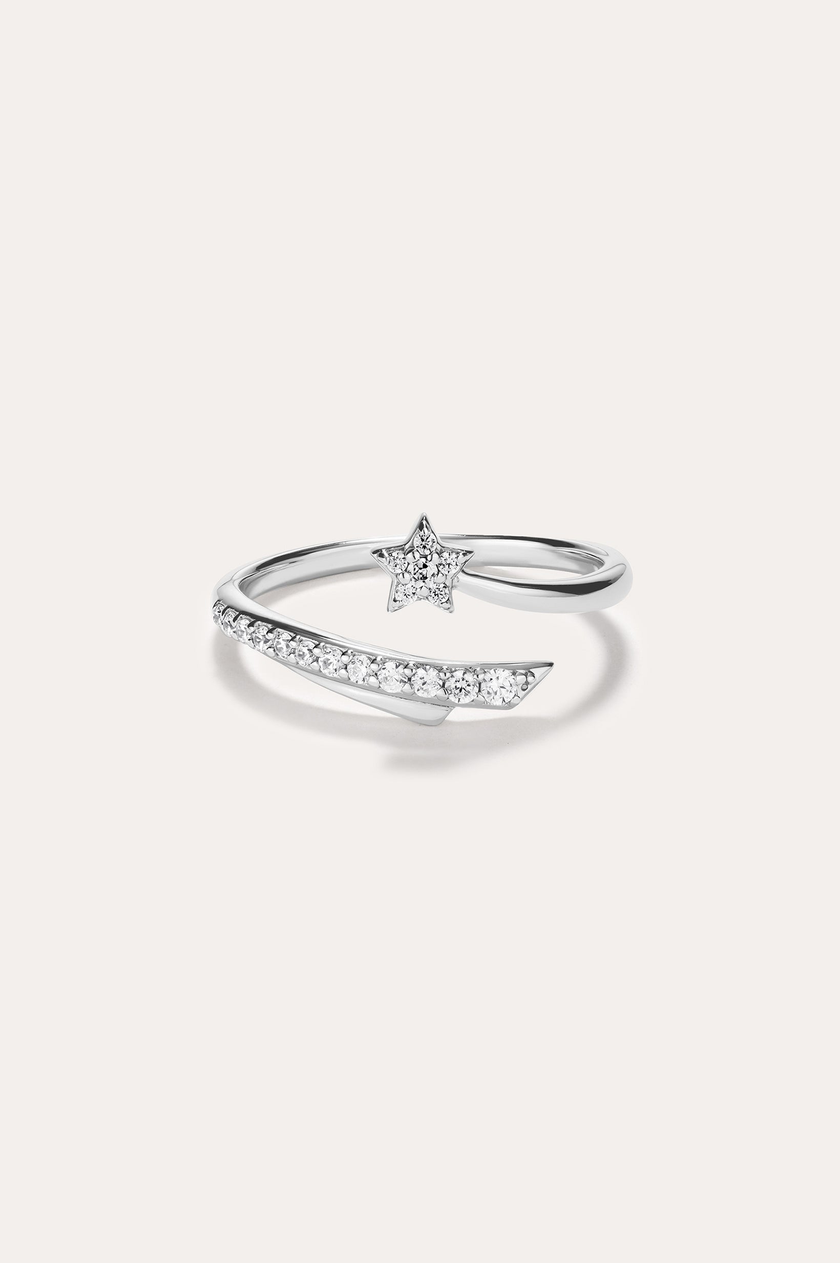 Introducing the Crystal Shooting Star Open Ring in Silver—a sterling silver adjustable ring with a wraparound design, showcasing a small star embellished with clear gemstones and a partially encrusted band of sparkling stones, evoking the delicate beauty of a crystal shooting star.