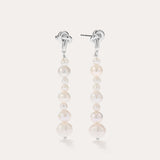 Introducing the Knot Multi Pearl Drop Earrings in Sterling Silver: this pair features a row of lustrous white freshwater pearls in varying sizes, elegantly set on sterling silver posts and showcased against a plain light background.