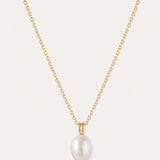A 14K gold plated chain necklace, featuring a single round white freshwater pearl pendant at its center, is displayed on a plain light background. The Freshwater Pearl Necklace in Gold includes an adjustable slider chain for a perfect fit with any neckline.
