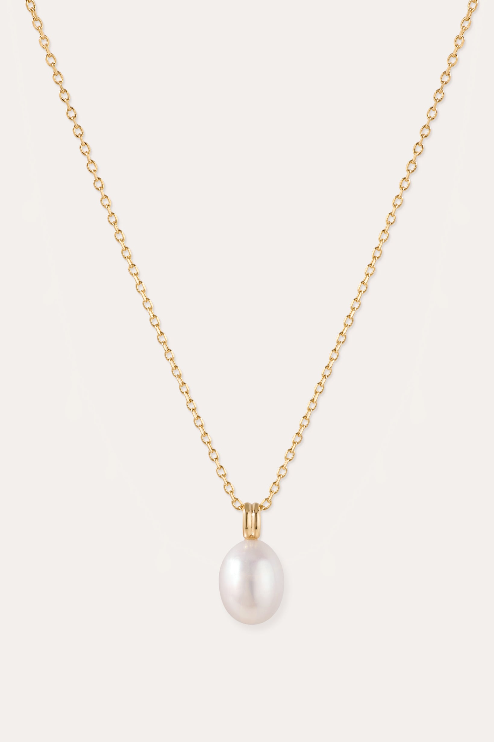 A 14K gold plated chain necklace, featuring a single round white freshwater pearl pendant at its center, is displayed on a plain light background. The Freshwater Pearl Necklace in Gold includes an adjustable slider chain for a perfect fit with any neckline.