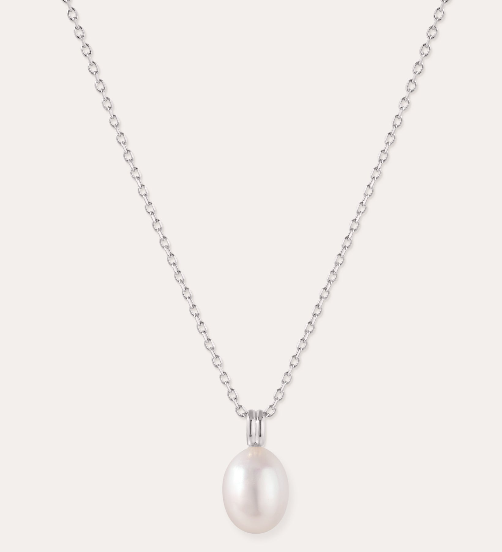 Introducing the Freshwater Pearl Necklace in Silver—a striking jewelry piece showcasing a single round white pearl pendant, elegantly suspended from a sterling silver adjustable slider chain and set against a plain light background.