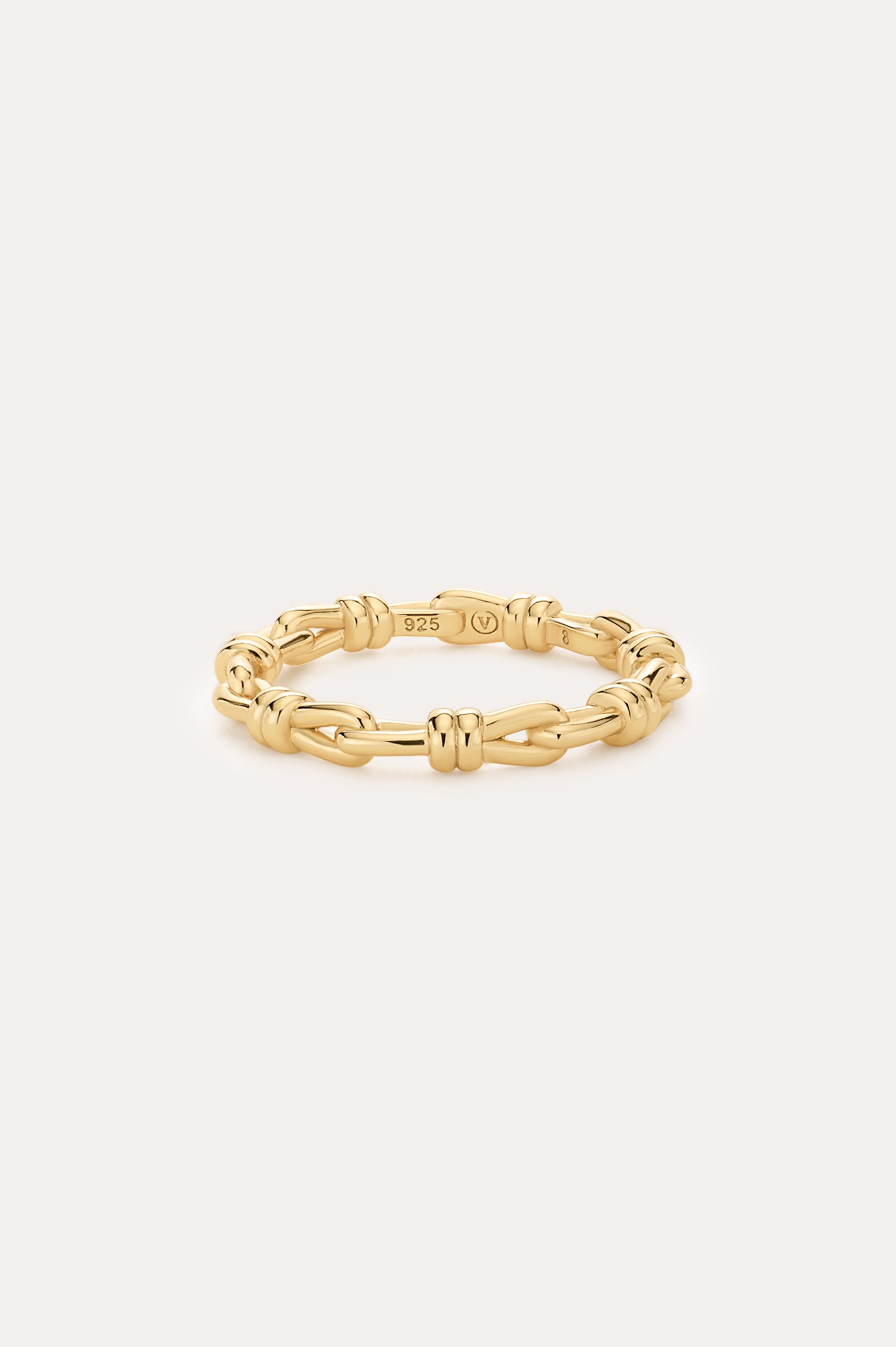The Noa Link Ring in Gold features 14K gold plating and delicate knot details, with a 925 stamp on the inside. Set against a plain light background, it’s perfect for stacking and elevating your everyday style.