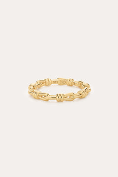 The Noa Link Ring in Gold features 14K gold plating and delicate knot details, with a 925 stamp on the inside. Set against a plain light background, it’s perfect for stacking and elevating your everyday style.