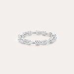 Introducing the Noa Link Ring in Silver: a thin sterling silver band featuring a series of chain-inspired, knot-like links evenly spaced around its circumference. Shown against a plain, light background, this elegant piece is the perfect stacking ring for any collection.