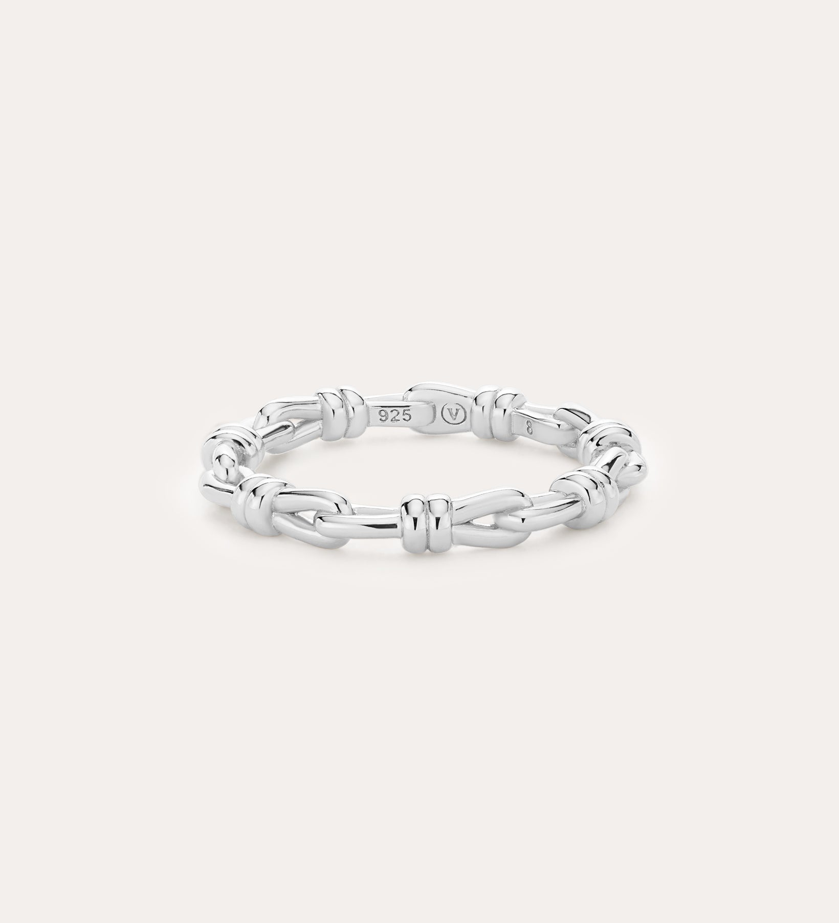 Introducing the Noa Link Ring in Silver: a thin sterling silver band featuring a series of chain-inspired, knot-like links evenly spaced around its circumference. Shown against a plain, light background, this elegant piece is the perfect stacking ring for any collection.
