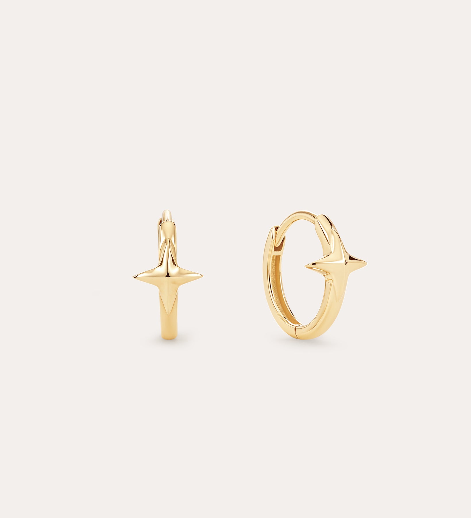 The 14K Recycled Solid Yellow Gold Star Huggie Earring features a polished star design in 14K yellow gold, perfect for your celestial ear stack. Shown against a plain, light background.