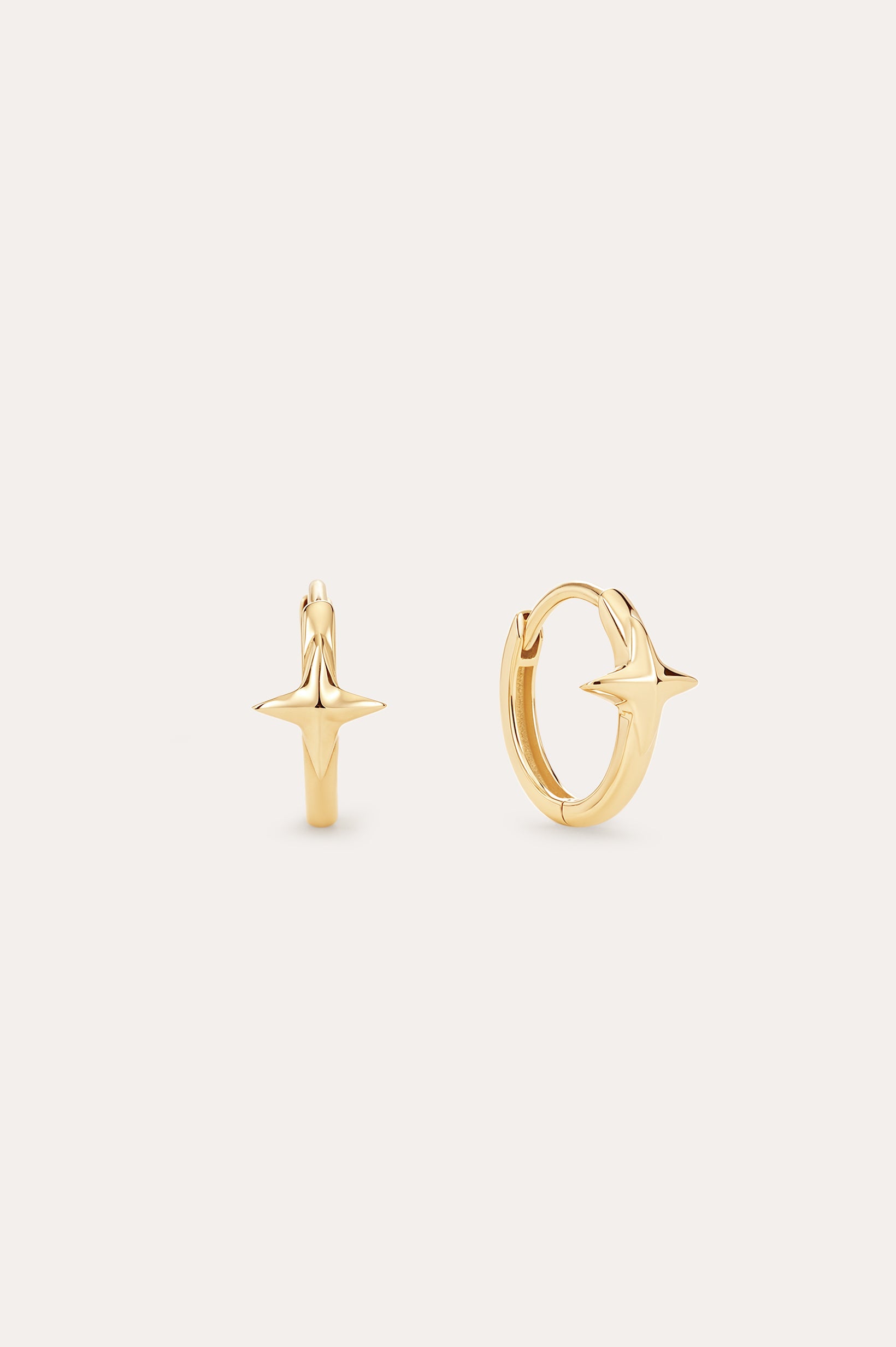 The 14K Recycled Solid Yellow Gold Star Huggie Earring features a polished star design in 14K yellow gold, perfect for your celestial ear stack. Shown against a plain, light background.