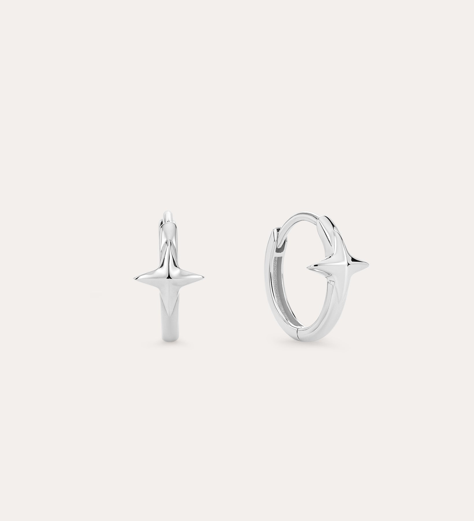A pair of 14K Recycled Solid White Gold Star Huggie Earrings, each with a four-pointed star charm, shown against a plain light background.