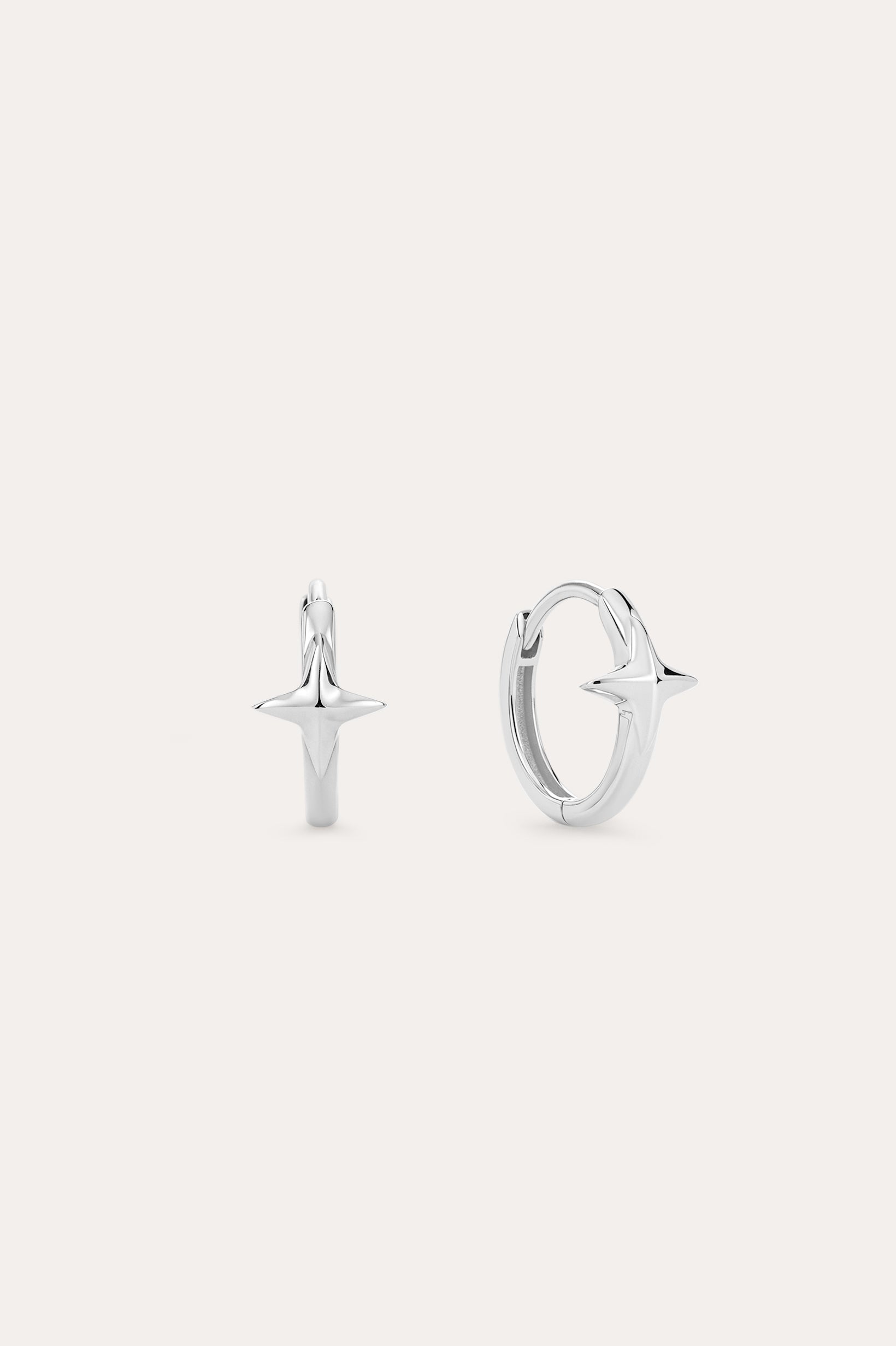A pair of 14K Recycled Solid White Gold Star Huggie Earrings, each with a four-pointed star charm, shown against a plain light background.