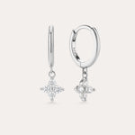 The Flora Crystal Charm Huggies in Sterling Silver feature dangling star-shaped charms with sparkling stones, shown against a plain light background.