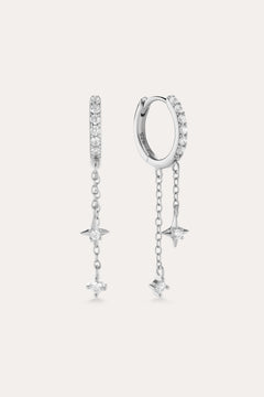 The Star Double Chain Dangle Huggies in Silver feature two sterling silver hoop earrings with star-shaped pendants and cubic zirconia stones along the front for an elegant, sparkling look.