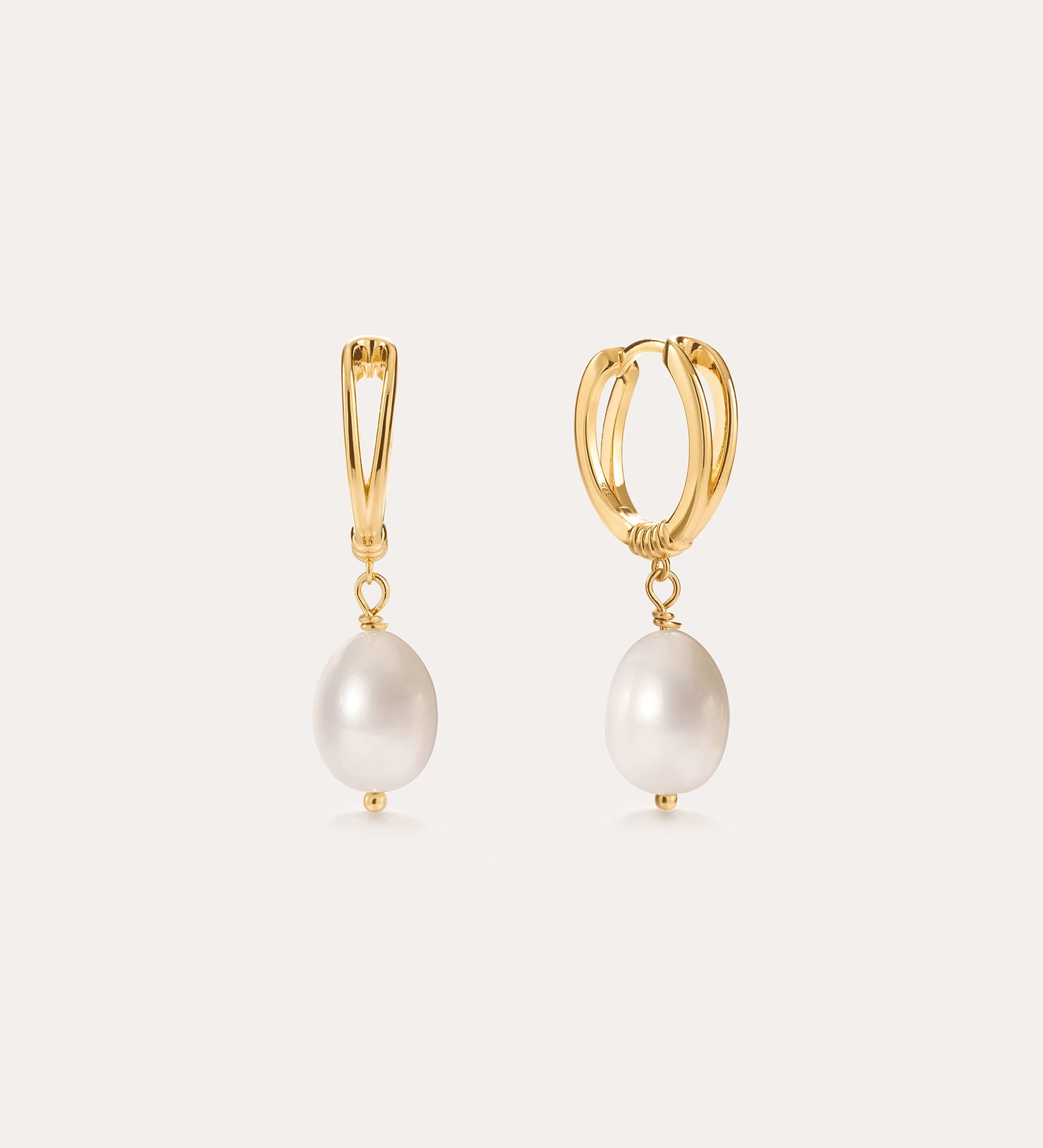 Introducing the Freshwater Pearl Charm Hoops in Gold—these 14K gold plated earrings each showcase a single white freshwater pearl drop, presented against a simple light background. Ideal for lovers of minimalist jewelry.
