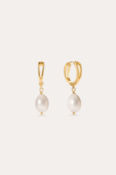 Introducing the Freshwater Pearl Charm Hoops in Gold—these 14K gold plated earrings each showcase a single white freshwater pearl drop, presented against a simple light background. Ideal for lovers of minimalist jewelry.