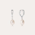 A pair of Freshwater Pearl Charm Huggies in Sterling Silver, each adorned with a single round white freshwater pearl, displayed on a plain light background—these earrings are the perfect everyday essential.
