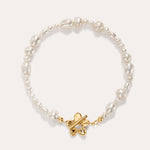 The Flora Multi Pearl Toggle Bracelet in Gold showcases irregular white freshwater pearls and features a 14K gold plated sterling silver butterfly-shaped toggle clasp at the center, elegantly displayed on a light background.
