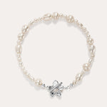 The Flora Multi Pearl Toggle Bracelet in Silver features irregular white freshwater pearls and a sterling silver floral toggle clasp shaped like a butterfly, elegantly displayed on a plain light background.