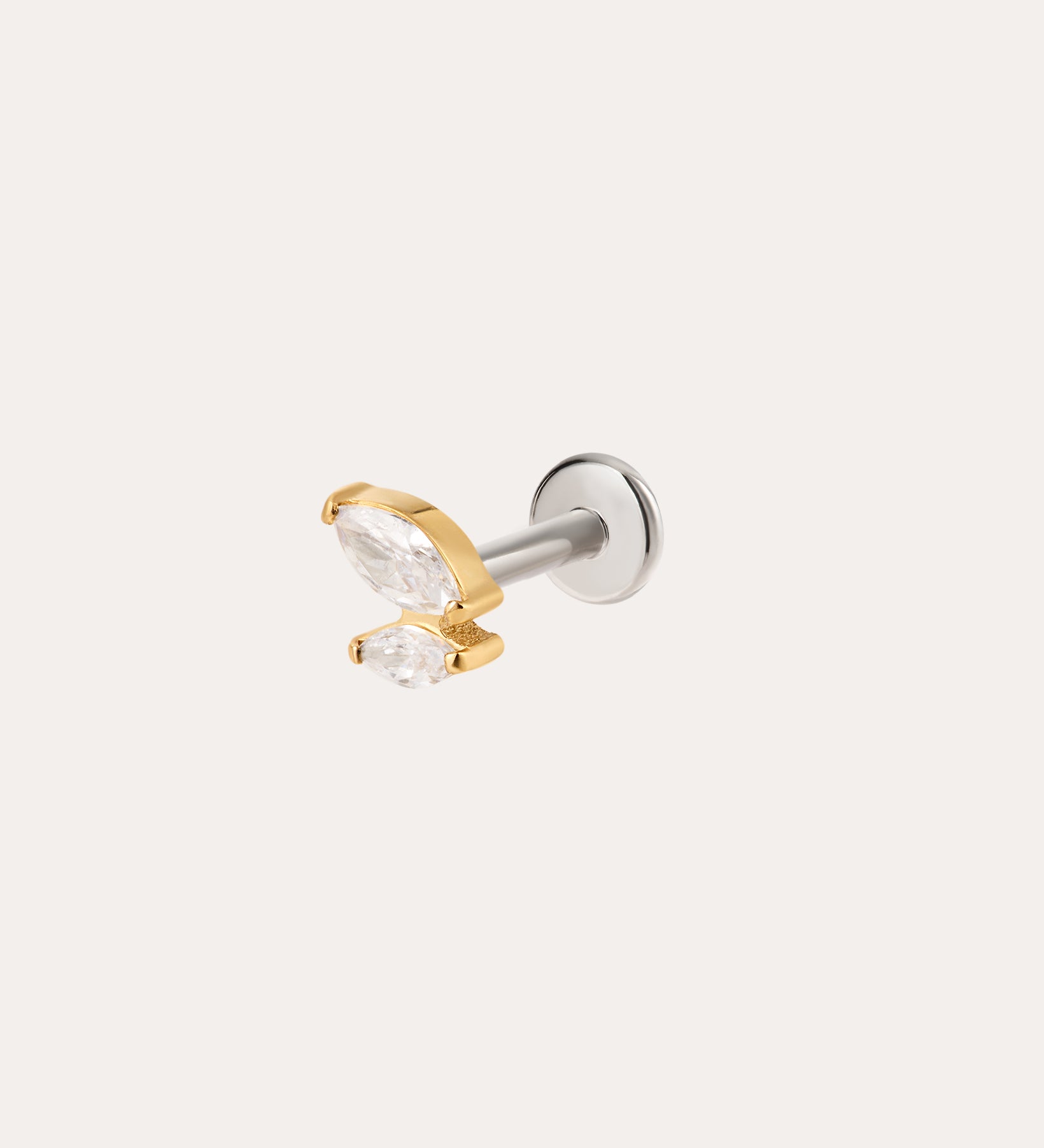 Introducing the Double Marquise Threadless Flat Back Titanium Cartilage Stud in Gold—crafted in sleek titanium with a luxurious yellow gold PVD finish, this refined piece showcases two clear marquise-cut gems in gold prongs atop a silver post. Designed as a flat back earring, it offers superior comfort and durability, making it the perfect choice for those seeking an elegant cartilage accessory.