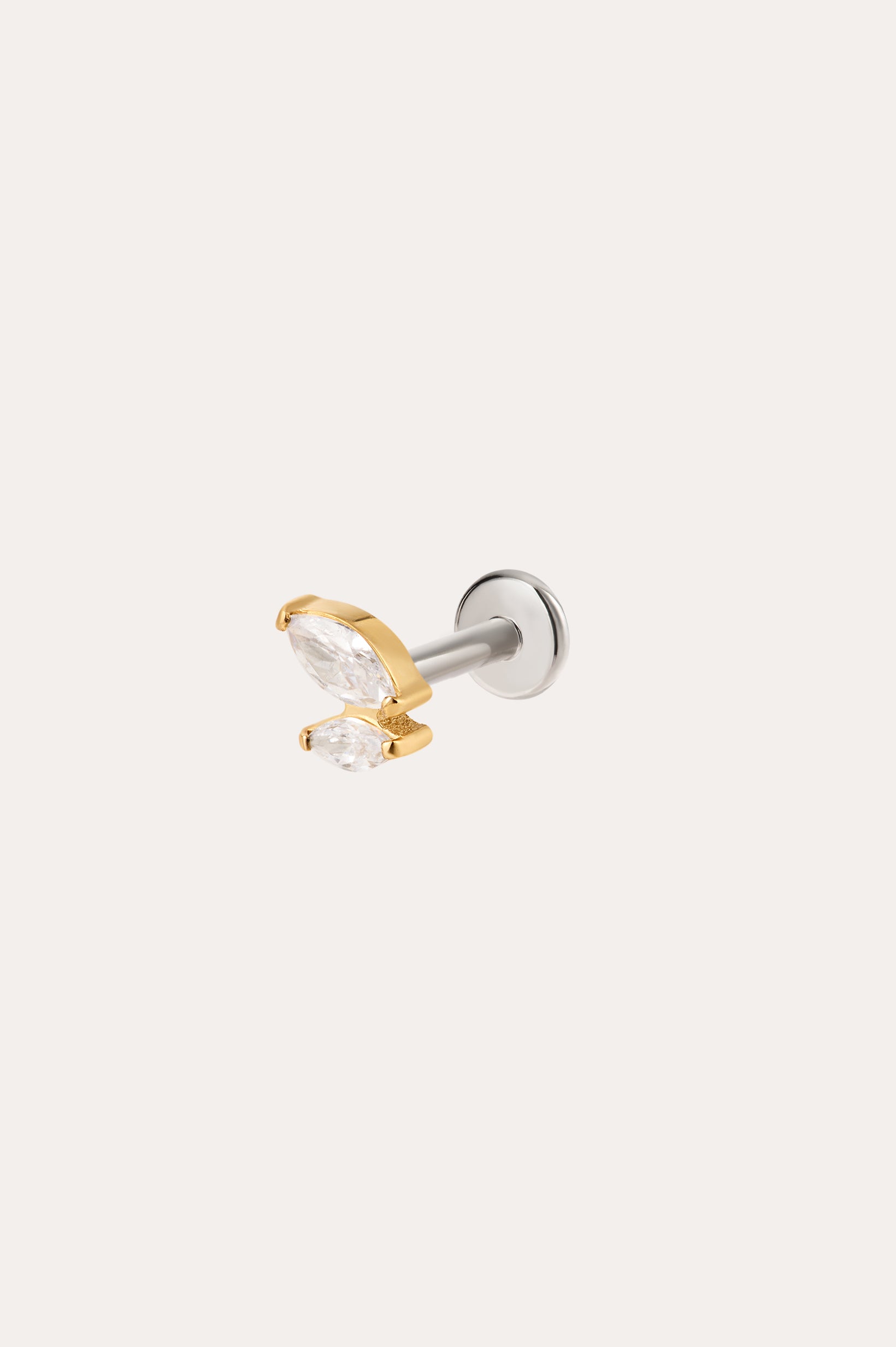 Introducing the Double Marquise Threadless Flat Back Titanium Cartilage Stud in Gold—crafted in sleek titanium with a luxurious yellow gold PVD finish, this refined piece showcases two clear marquise-cut gems in gold prongs atop a silver post. Designed as a flat back earring, it offers superior comfort and durability, making it the perfect choice for those seeking an elegant cartilage accessory.