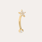 The Crystal Star Titanium Rook Barbell in Gold showcases a yellow gold PVD curved barbell design, featuring a star-shaped end embellished with sparkling clear gems and a single clear gem on the other end. Displayed against a plain light background, this crystal star rook barbell jewelry adds an elegant touch to any look.