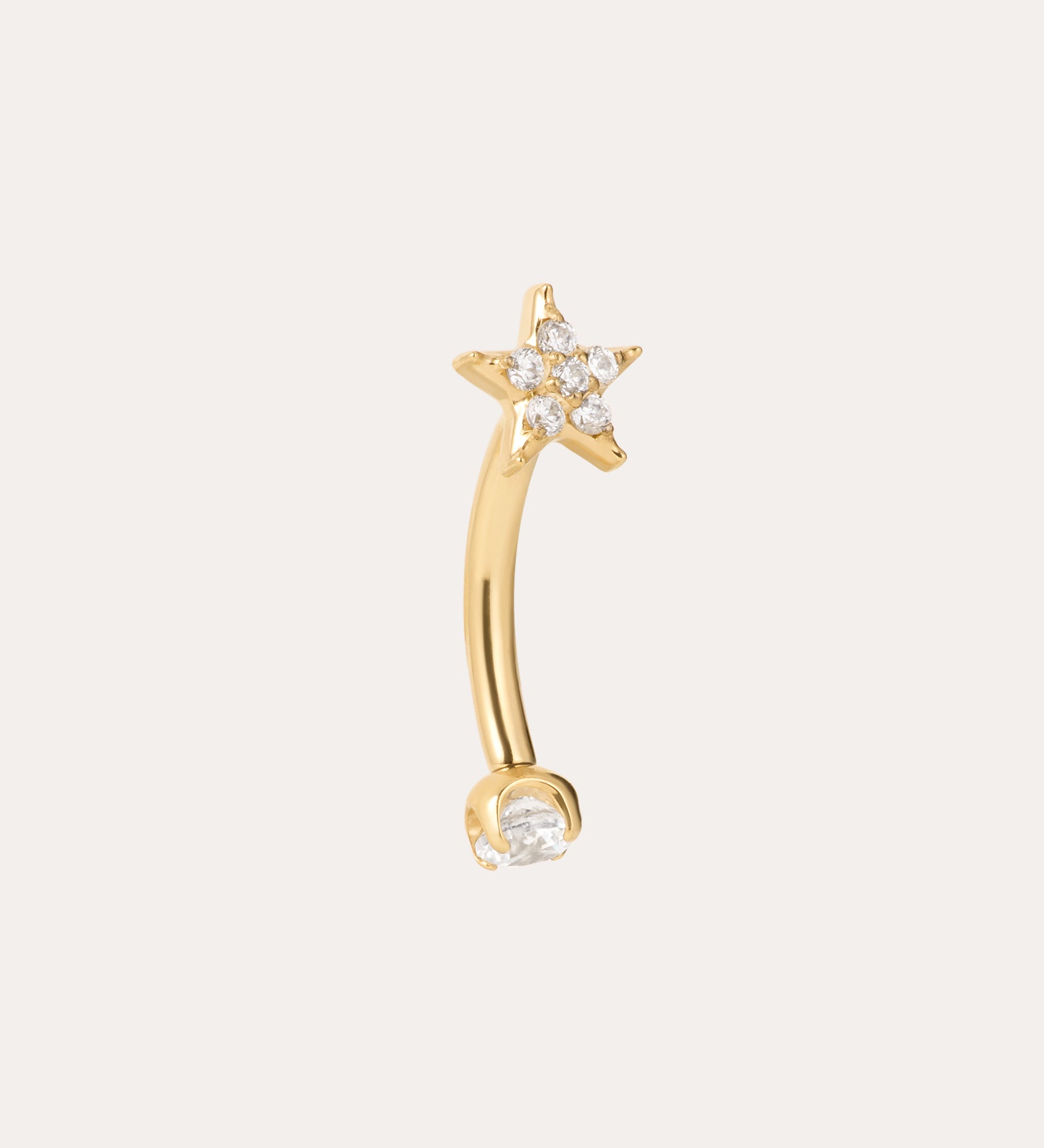 The Crystal Star Titanium Rook Barbell in Gold showcases a yellow gold PVD curved barbell design, featuring a star-shaped end embellished with sparkling clear gems and a single clear gem on the other end. Displayed against a plain light background, this crystal star rook barbell jewelry adds an elegant touch to any look.