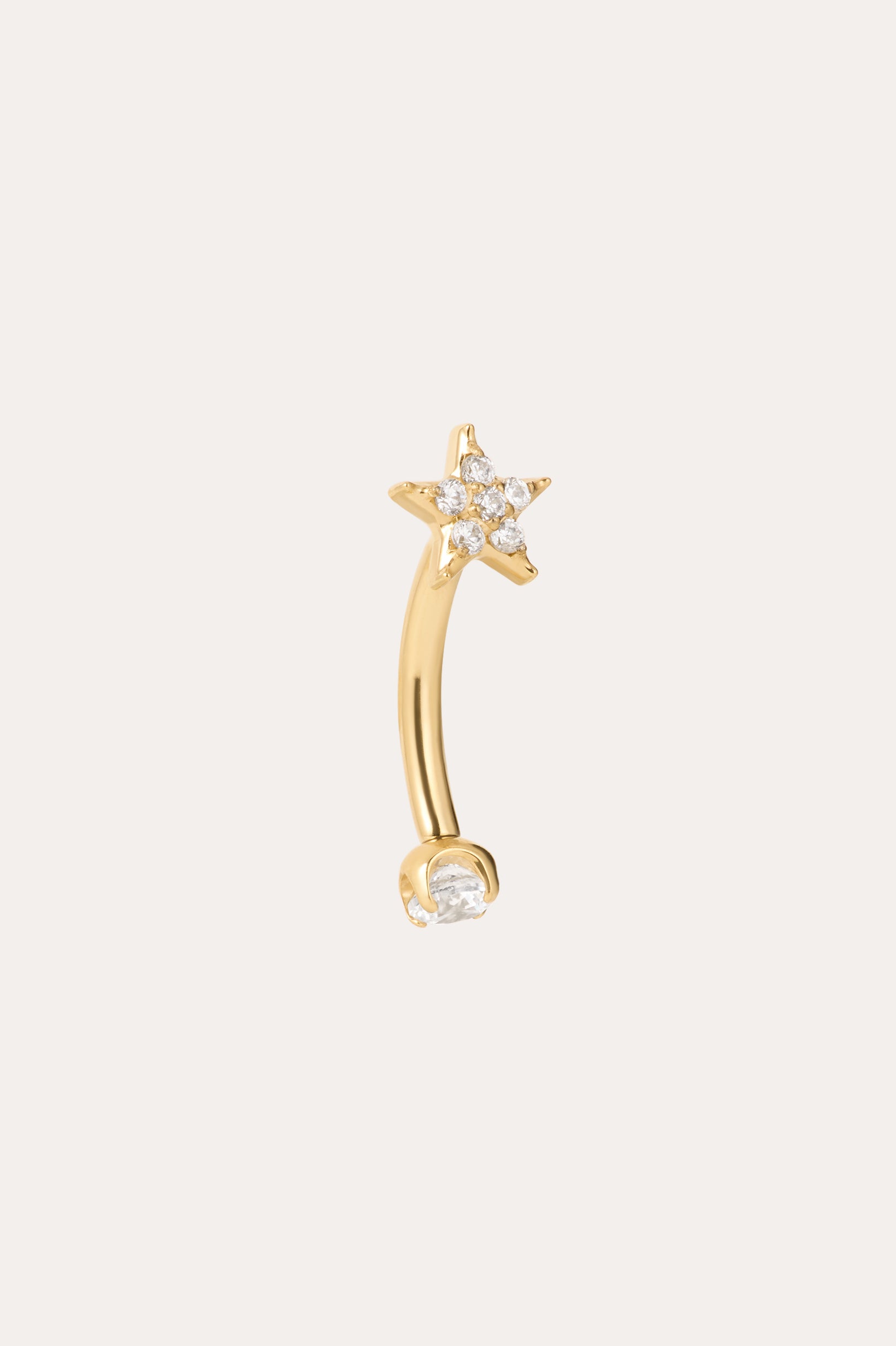 The Crystal Star Titanium Rook Barbell in Gold showcases a yellow gold PVD curved barbell design, featuring a star-shaped end embellished with sparkling clear gems and a single clear gem on the other end. Displayed against a plain light background, this crystal star rook barbell jewelry adds an elegant touch to any look.