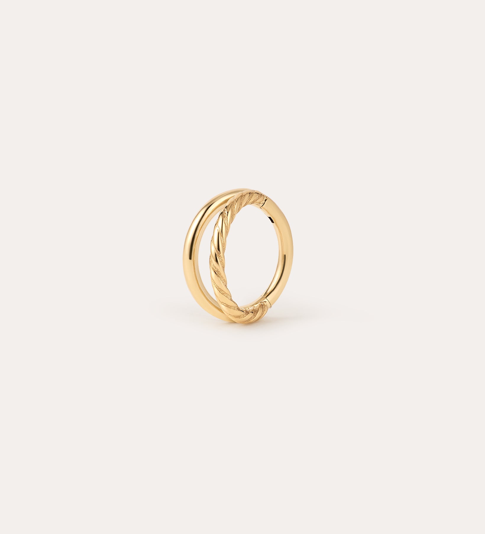Double Clicker Titanium Ring in Gold featuring two intertwined bands—one smooth, the other with a twisted rope design—in a Yellow Gold PVD finish, displayed against a plain, light background. Hypoallergenic and crafted for comfort, this elegant piece combines style and everyday wearability.