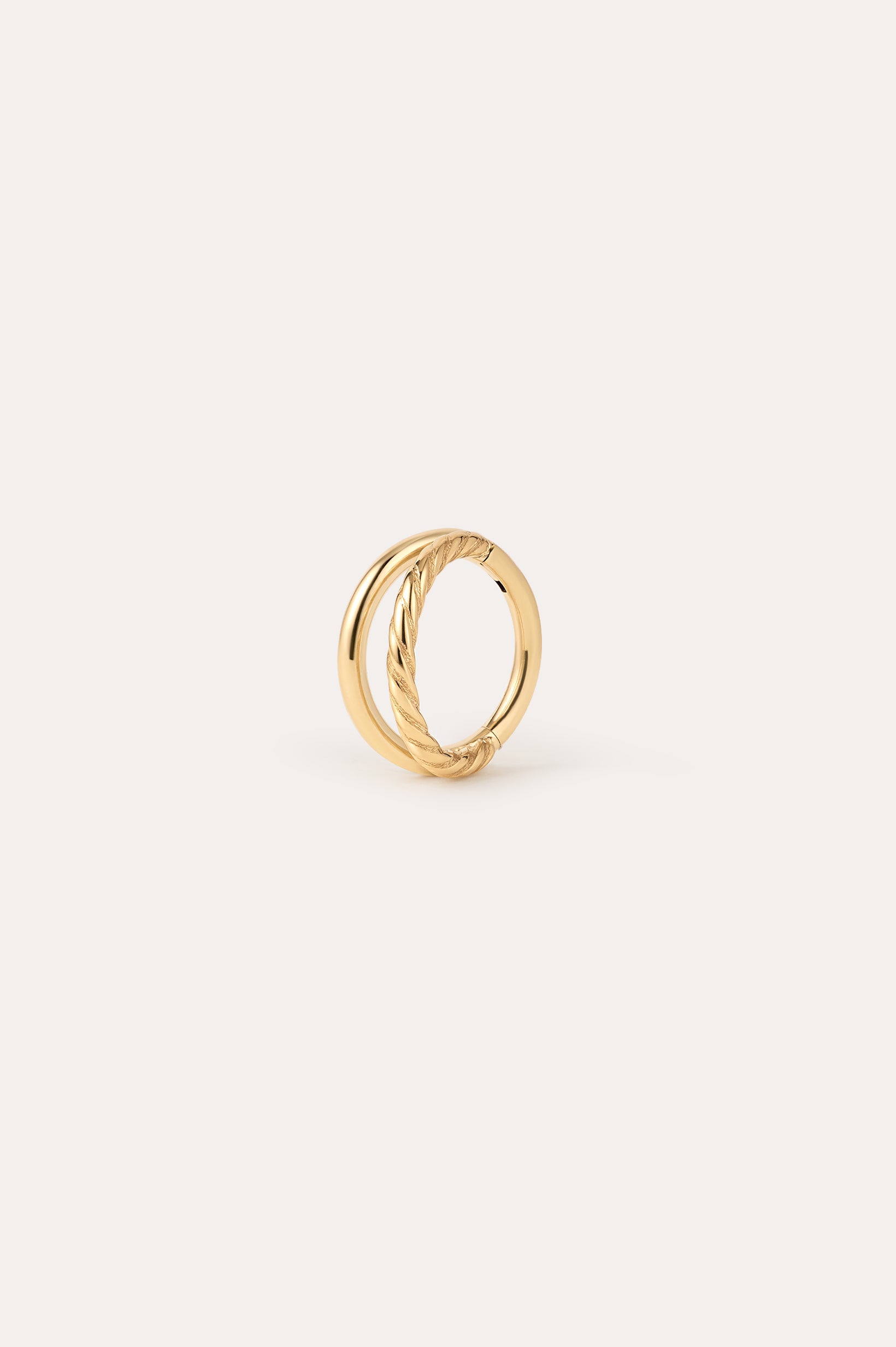 Double Clicker Titanium Ring in Gold featuring two intertwined bands—one smooth, the other with a twisted rope design—in a Yellow Gold PVD finish, displayed against a plain, light background. Hypoallergenic and crafted for comfort, this elegant piece combines style and everyday wearability.
