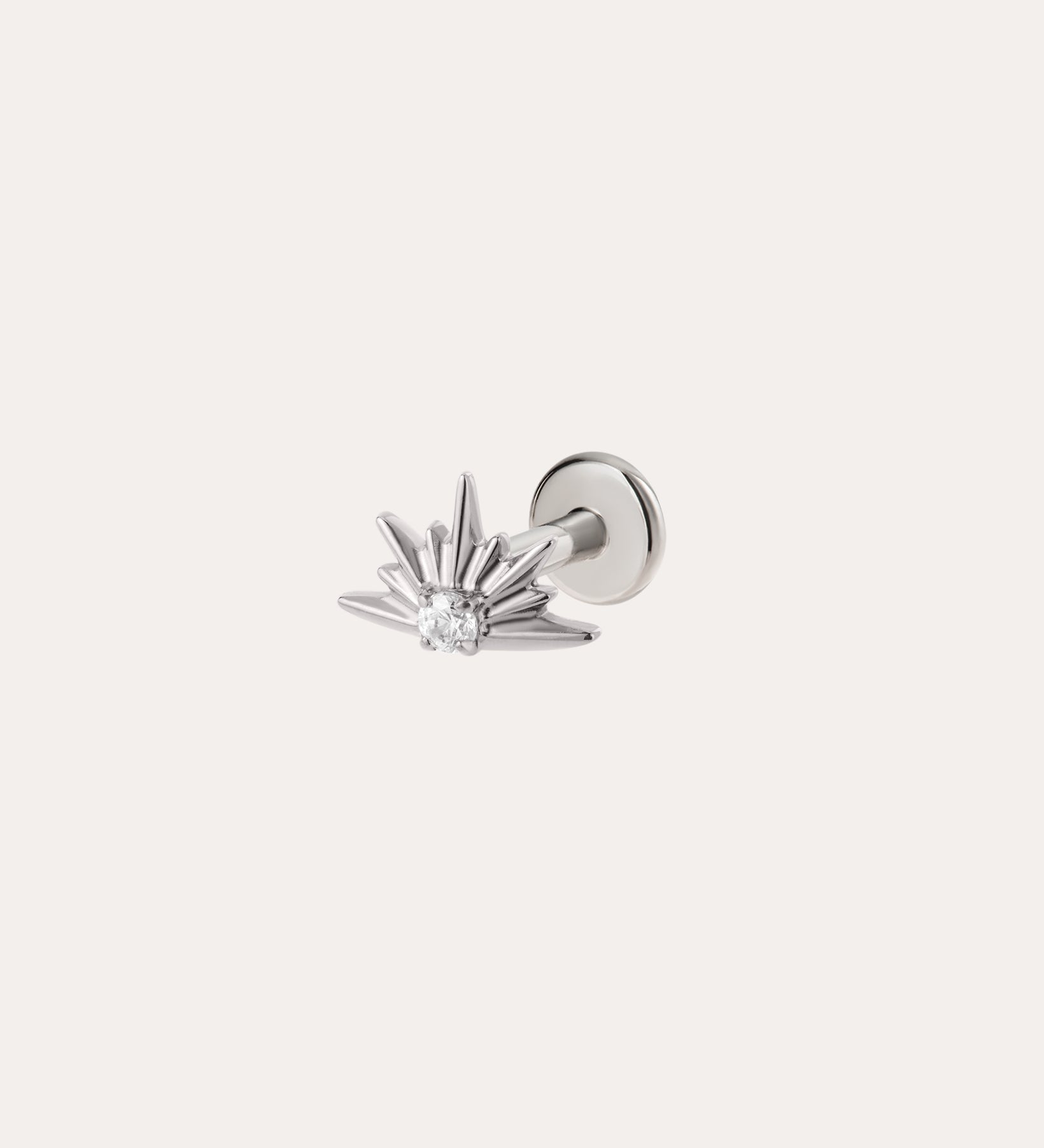 A platinum PVD Sunburst Threadless Flat Back Titanium Cartilage Stud features a radiant sunburst design with a central clear gemstone and is displayed on a plain light background. This hypoallergenic earring offers a comfortable threadless flat back, making it perfect for stylish all-day wear.