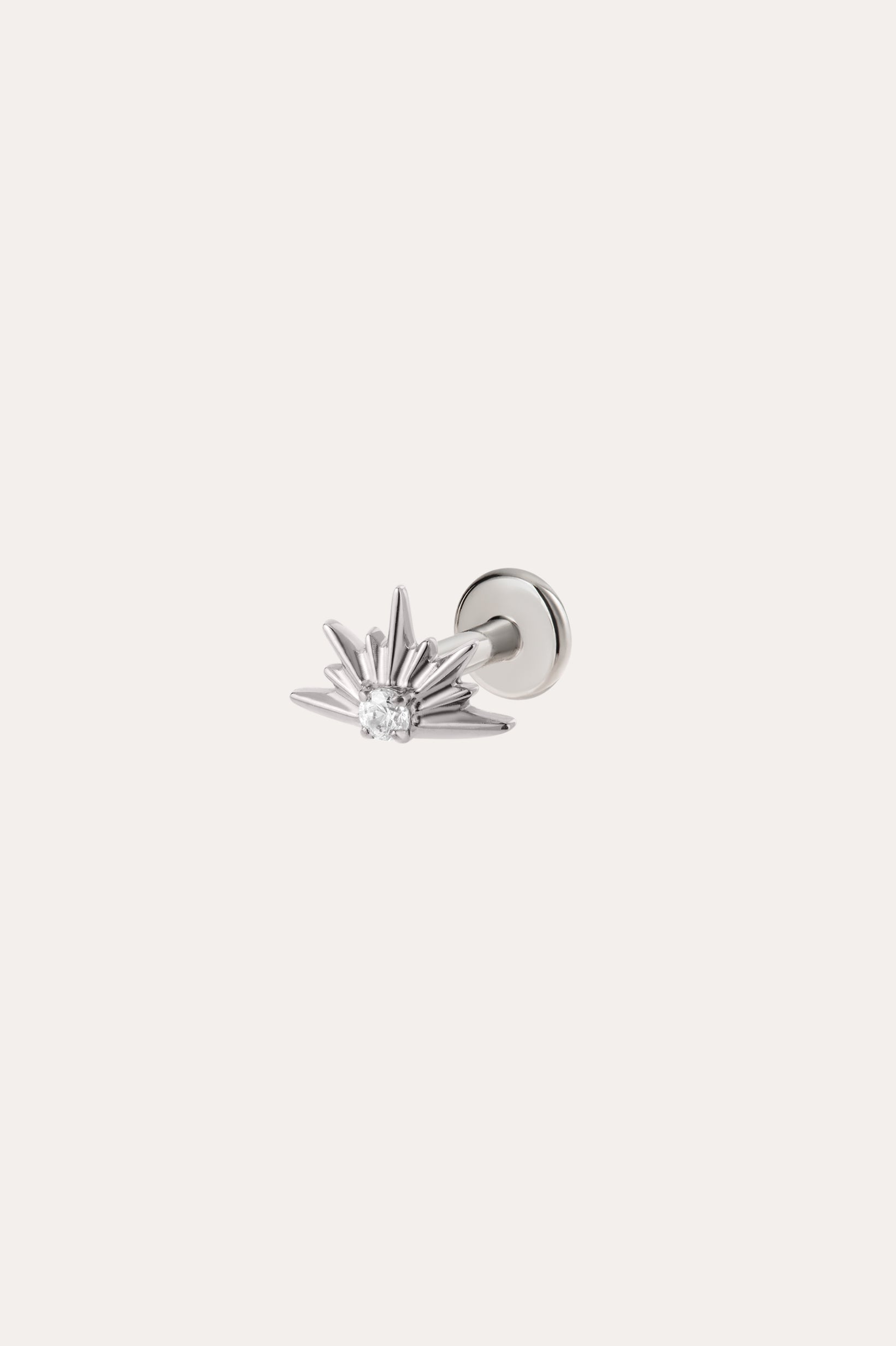 A platinum PVD Sunburst Threadless Flat Back Titanium Cartilage Stud features a radiant sunburst design with a central clear gemstone and is displayed on a plain light background. This hypoallergenic earring offers a comfortable threadless flat back, making it perfect for stylish all-day wear.