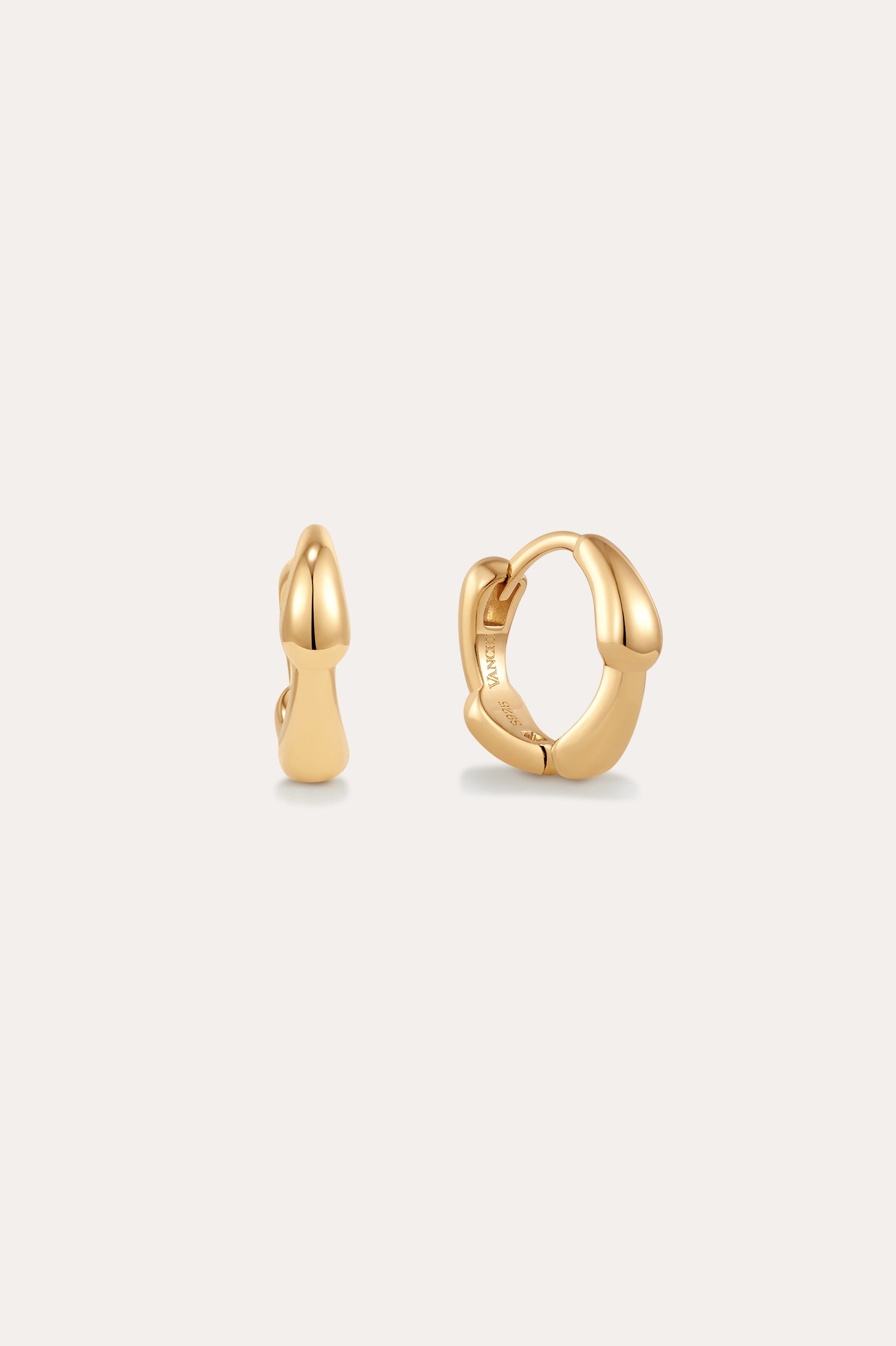 The Colette Droop Link Huggie Earrings in Gold feature smooth, rounded organic curves, showcased against a plain light background.