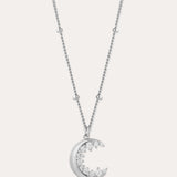 The Crescent Moon Crystal Charm Beaded Necklace in Silver features a delicate beaded chain and a crescent moon pendant adorned with sparkling clear stones.