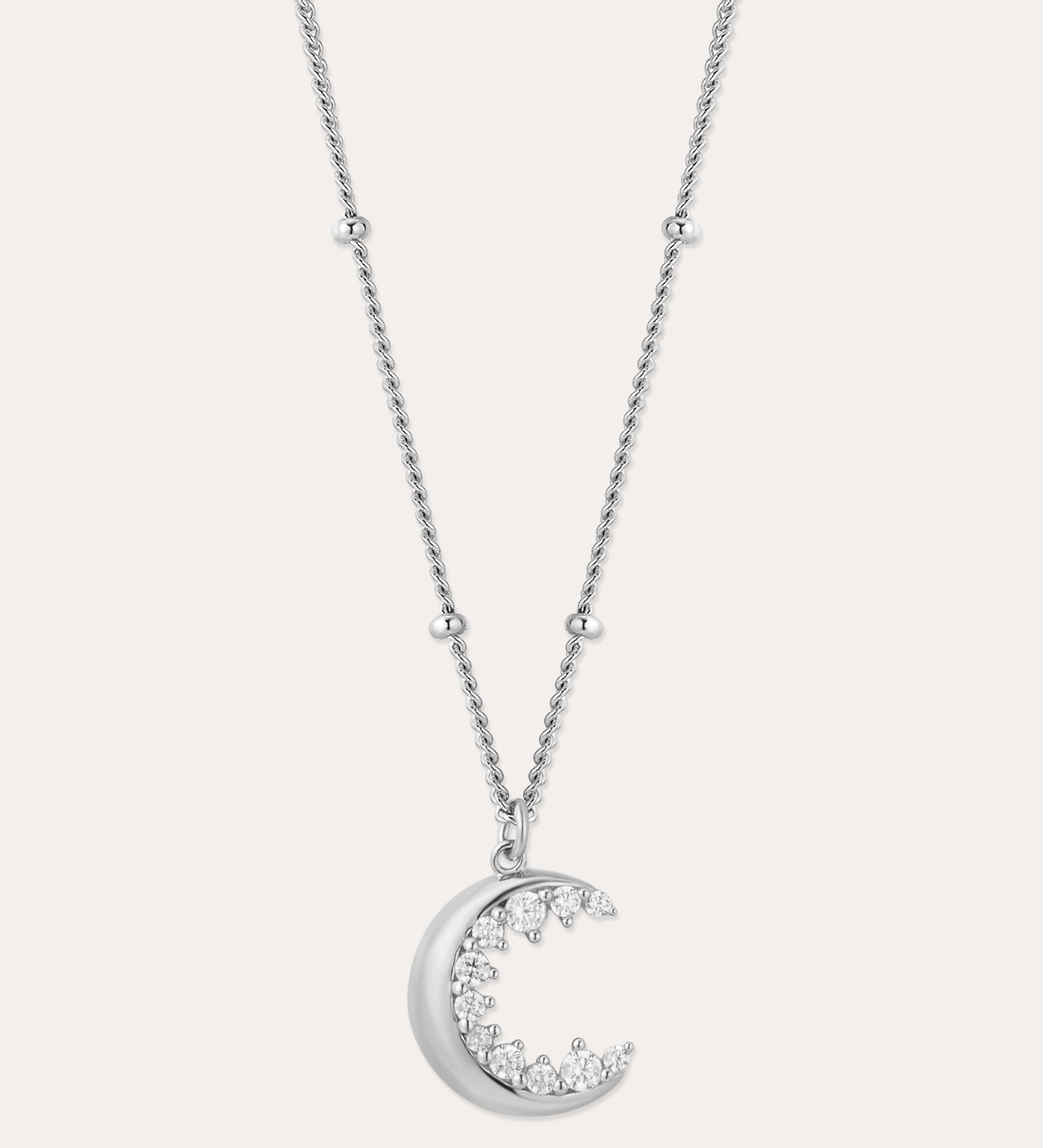 The Crescent Moon Crystal Charm Beaded Necklace in Silver features a delicate beaded chain and a crescent moon pendant adorned with sparkling clear stones.