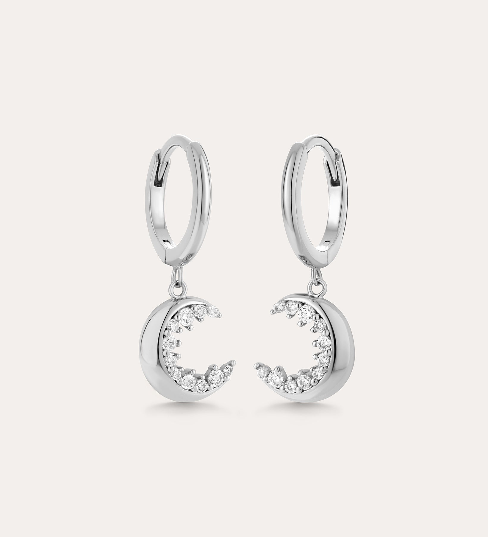 Crescent Moon Crystal Charm Huggies in Silver feature dangling crescent moon charms with sparkling cubic zirconia, shown on a light background.